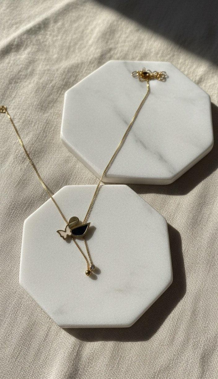 Necklace on a hexagonal marble coaster with a soft background