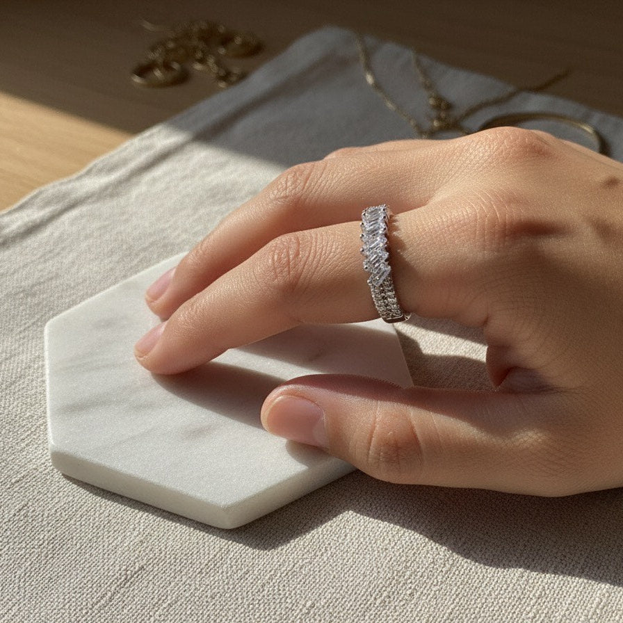 Hand wearing a silver ring on a marble coaster with a neutral background