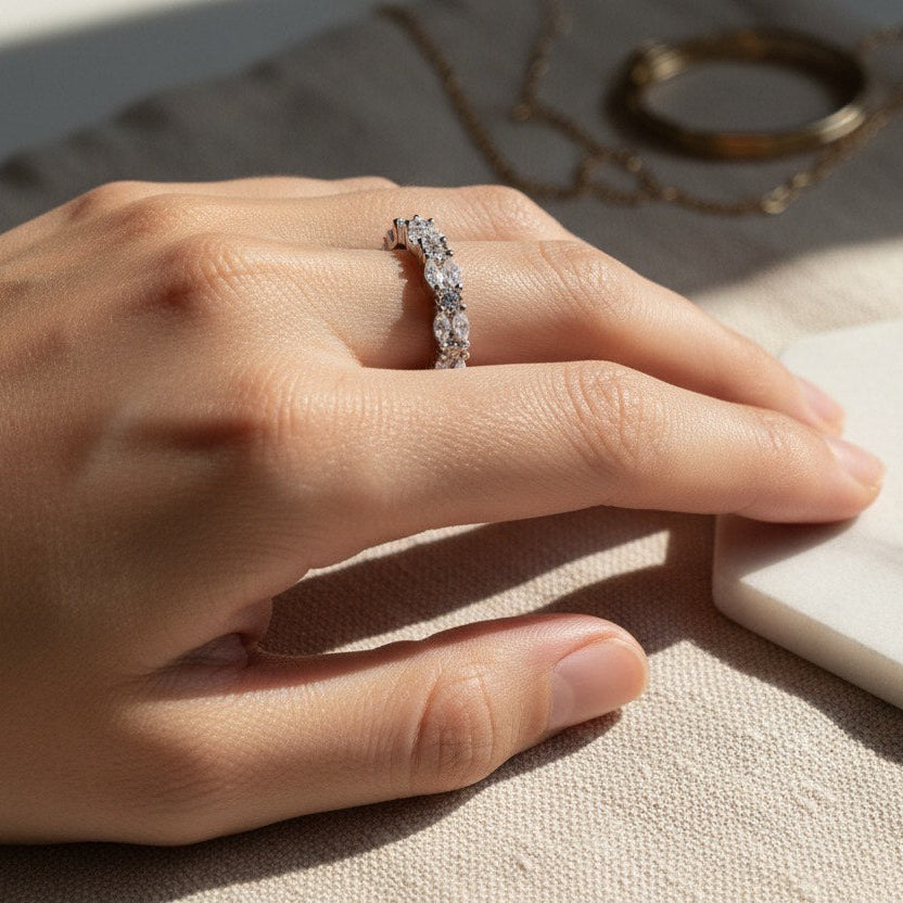 Hand wearing a diamond ring on a marble surface