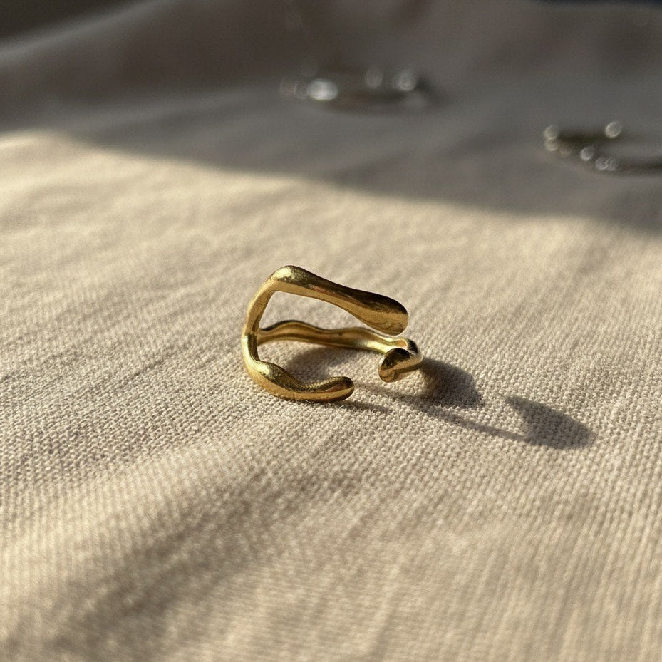 Gold ring on a textured beige surface