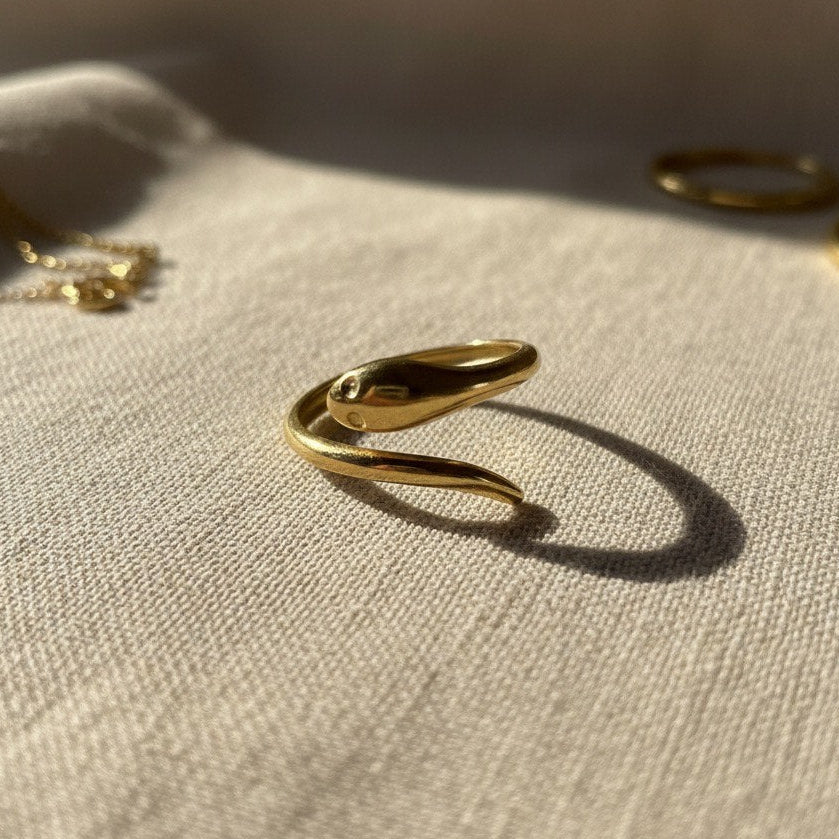 Gold ring on a textured beige surface with soft lighting