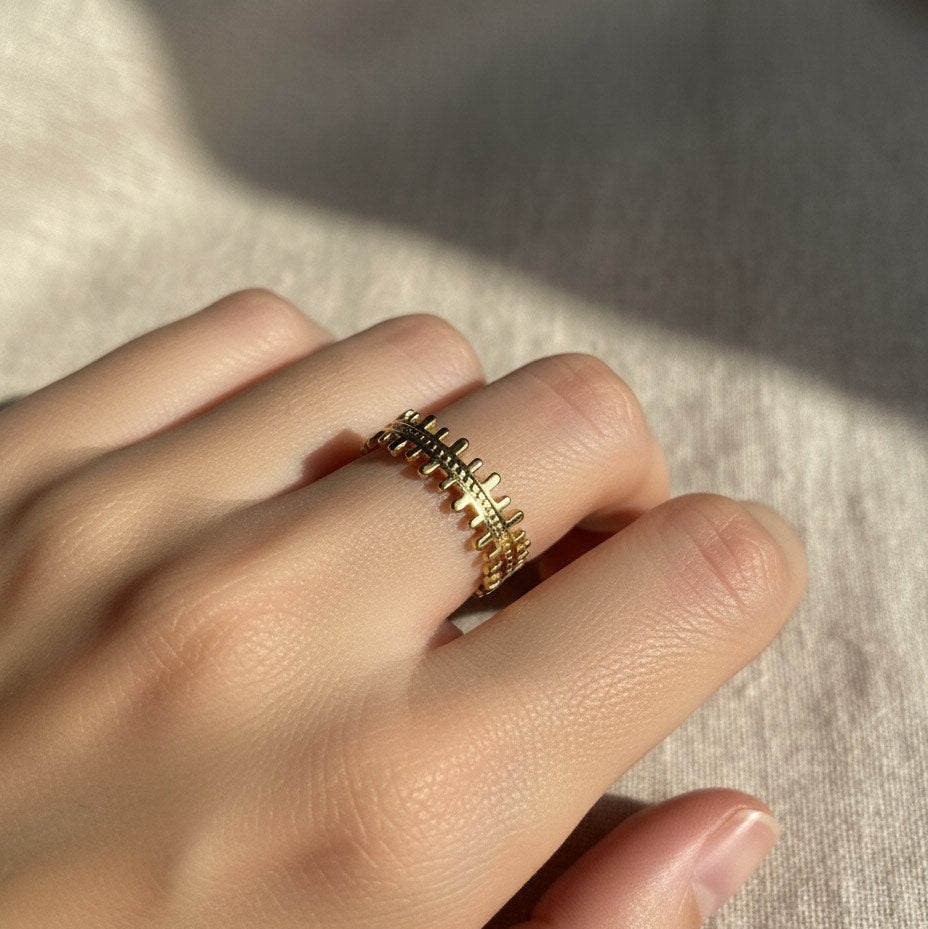 Gold ring on a hand with a neutral background