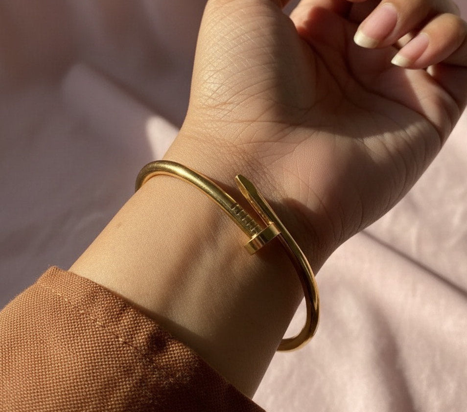 Gold bracelet on a wrist with a soft background