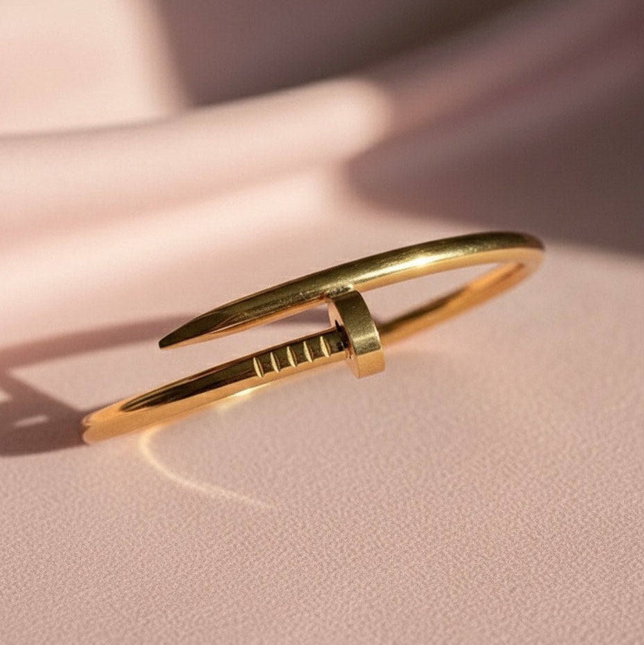 Gold bracelet on a pink background