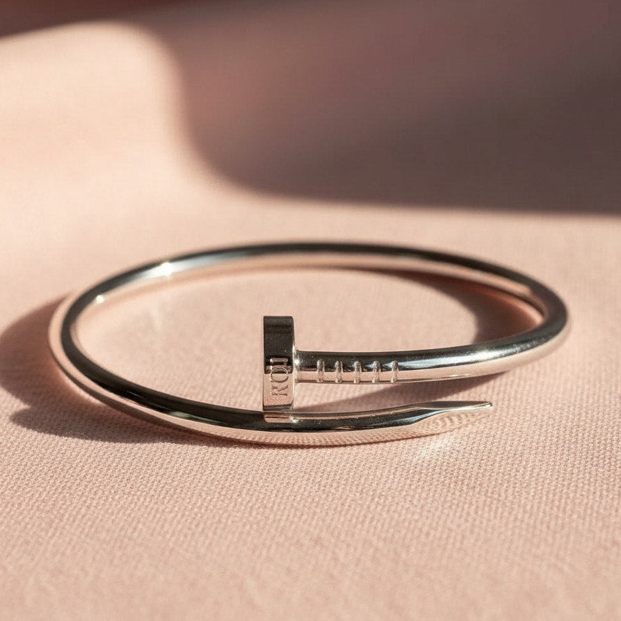 Silver bracelet on a pink fabric background