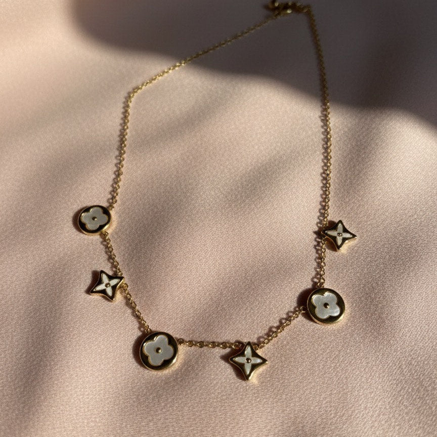 Necklace with star-shaped pendants on a soft pink background